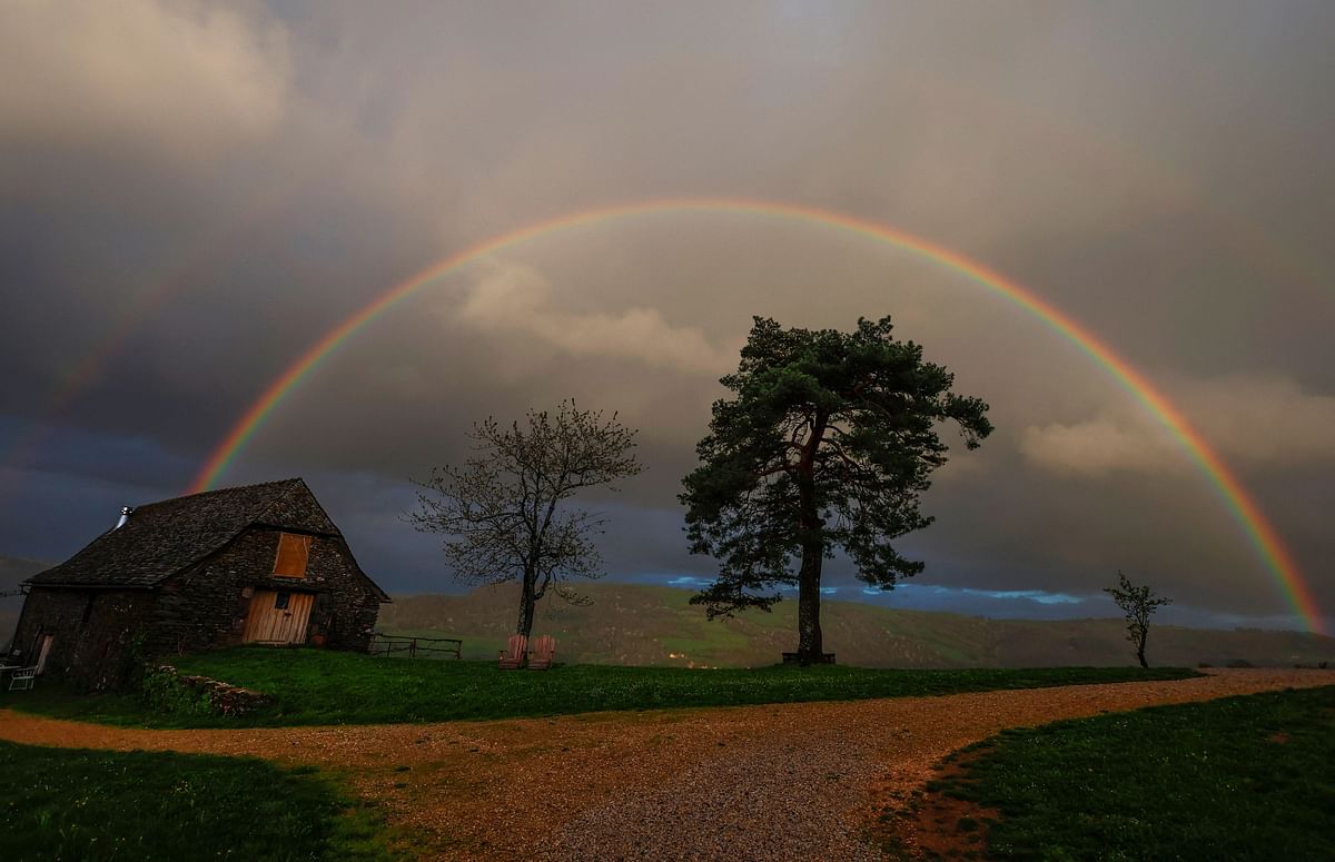 A rainbow shines in the sky over the La Bessayrie hamlet at sunset near Conques, south of France, April 9, 2024.
