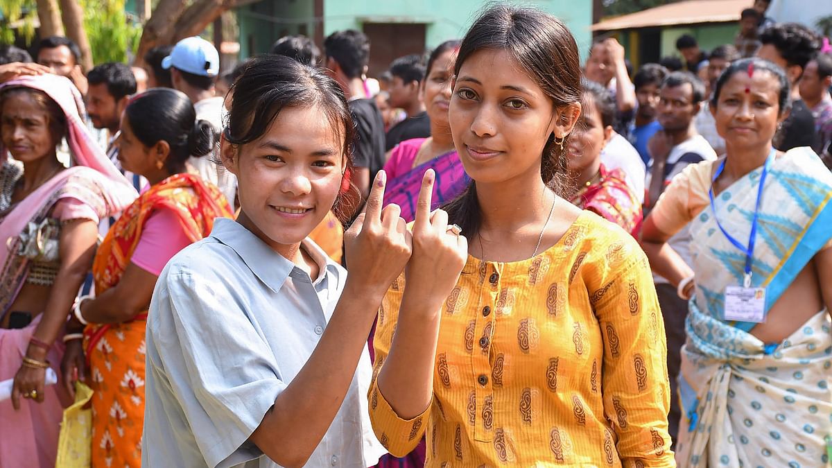 First-time voters show their fingers marked with indelible ink after casting their votes for the second phase of Lok Sabha elections in Morigaon district of Assam.