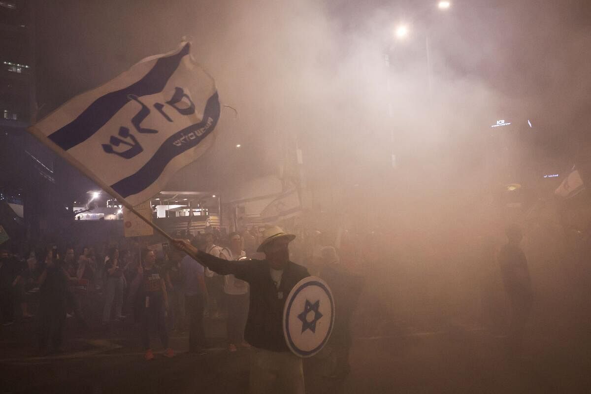 People take part in a protest calling for the release of hostages kidnapped in the deadly October 7 attack on Israel by the Palestinian Islamist group Hamas, in Tel Aviv, Israel, April 29, 2024. The words in Hebrew on the flag read "Peace".
