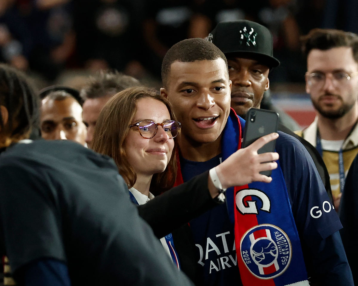Paris St Germain's Kylian Mbappe takes a selfie with fans after winning the Ligue 1