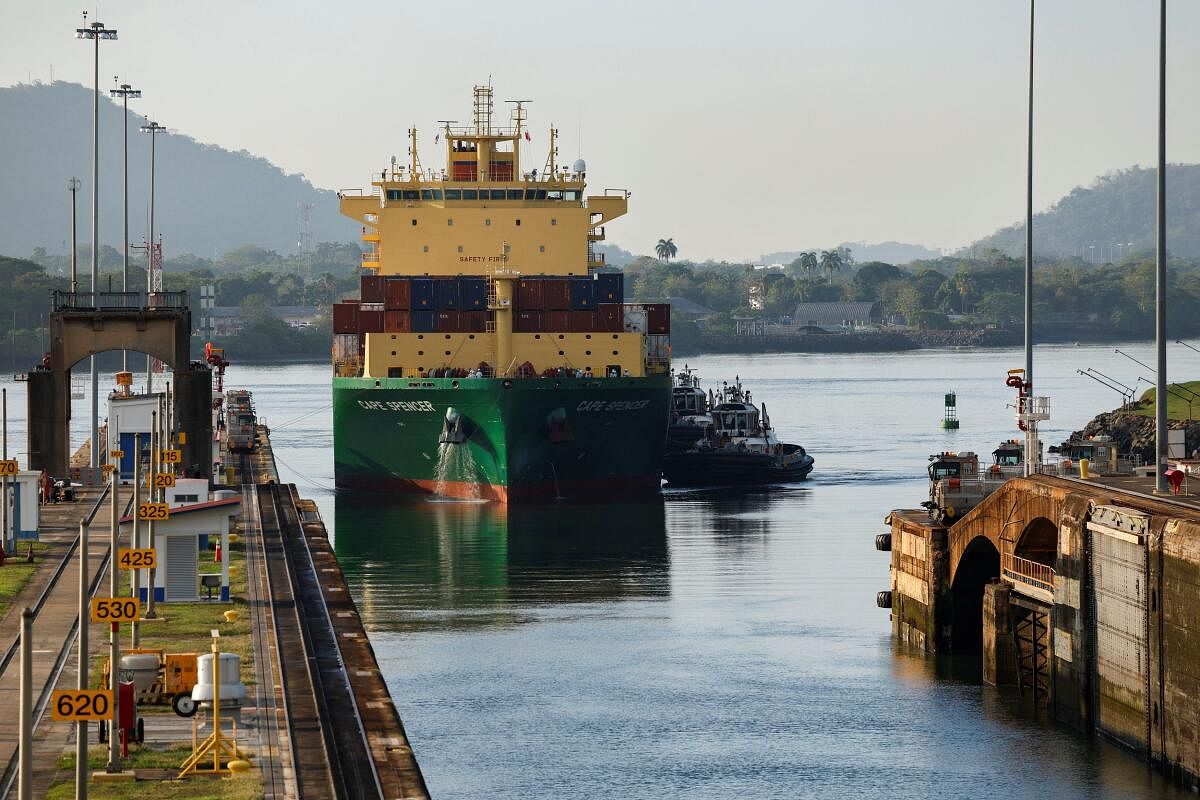 A cargo vessel is assisted by tugboats as vessels transit through the Panama Canal, in Panama City.