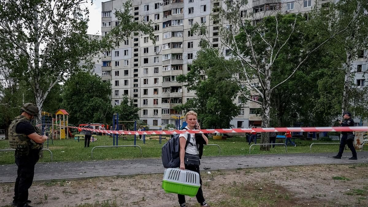 A local resident reacts as she stands near her apartment building damaged by a Russian air strike, amid Russia's attack on Ukraine, in Kharkiv, Ukraine May 22, 2024.