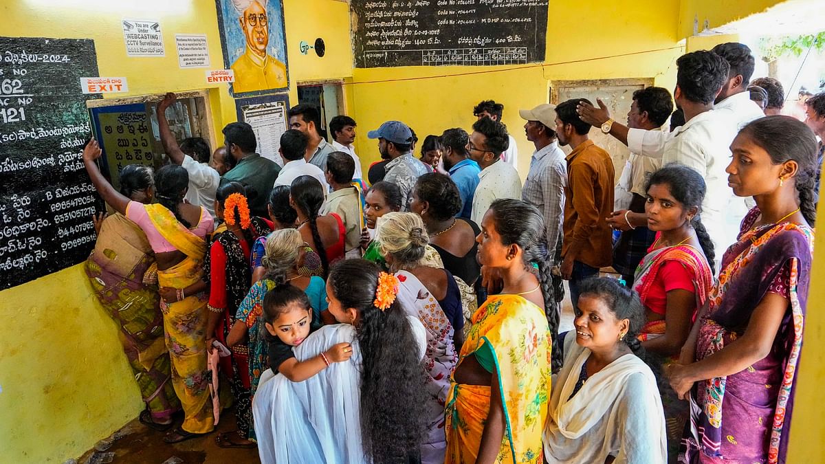 Voters stand in a queue at a polling station to cast their votes for the fourth phase of Lok Sabha elections and Andhra Pradesh Assembly elections, in Tirupati.