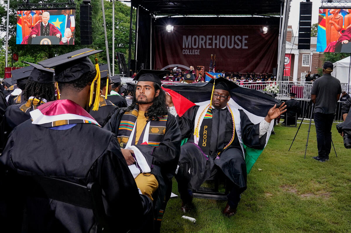 A Morehouse College graduate with his back turned holds a Palestinian flag while U.S. President Joe Biden speaks during a commencement ceremony in Atlanta, Georgia, U.S., May 19, 2024.