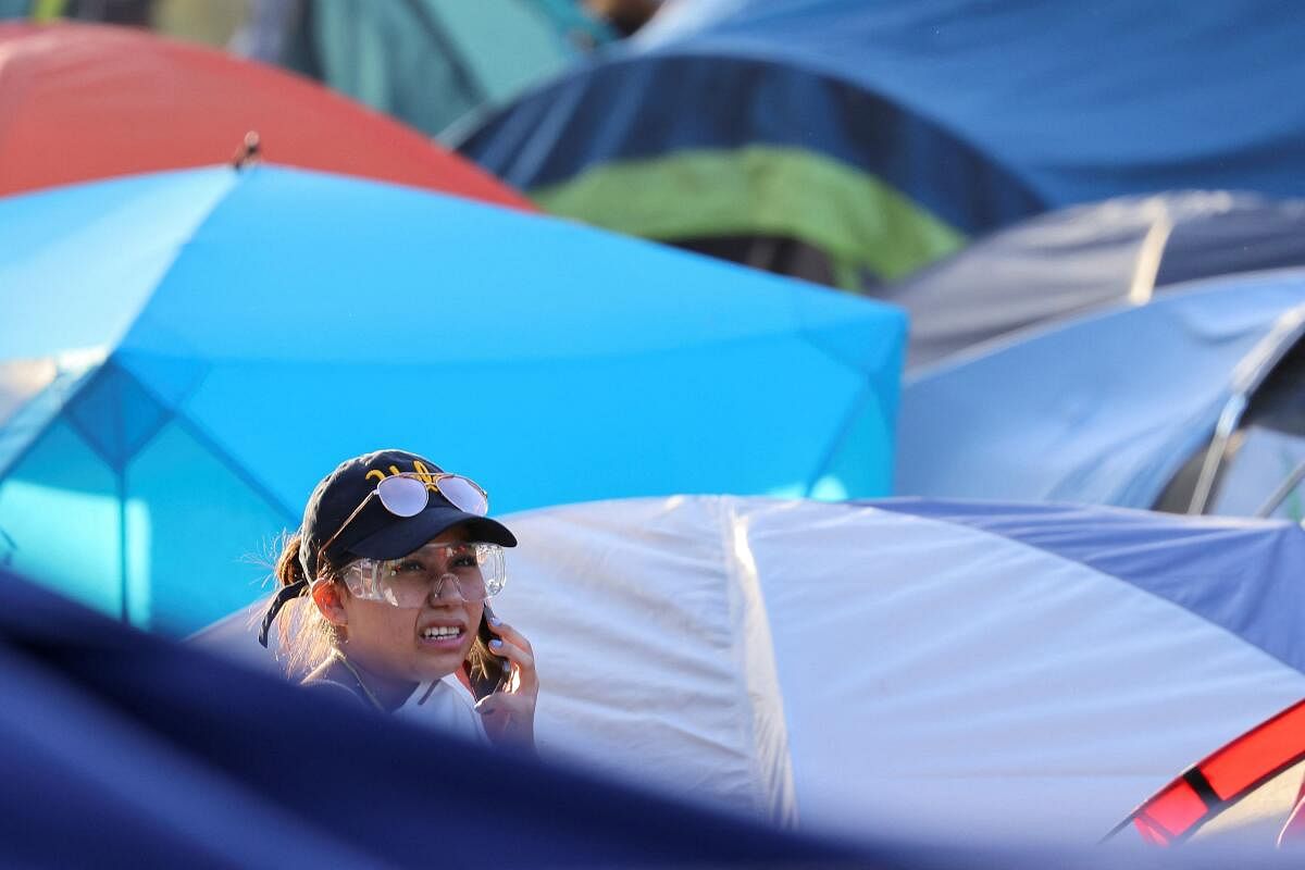A protester supporting Palestinians in Gaza speaks on a phone among the tents at an encampment after the UCLA campus police asked protesters to leave, at the UCLA.