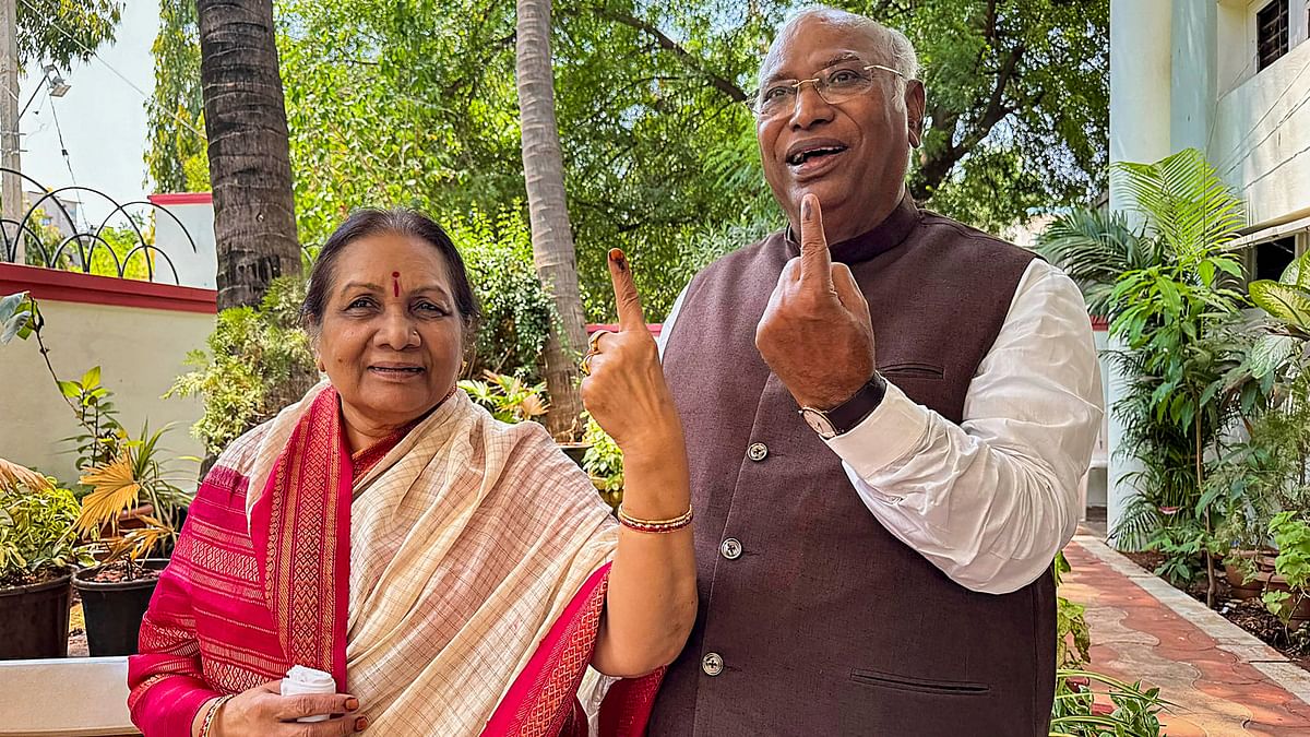 Congress President Mallikarjun Kharge with his wife Radhabai Kharge shows his ink-marked finger after voting during the third phase of Lok Sabha elections, in Kalaburagi.