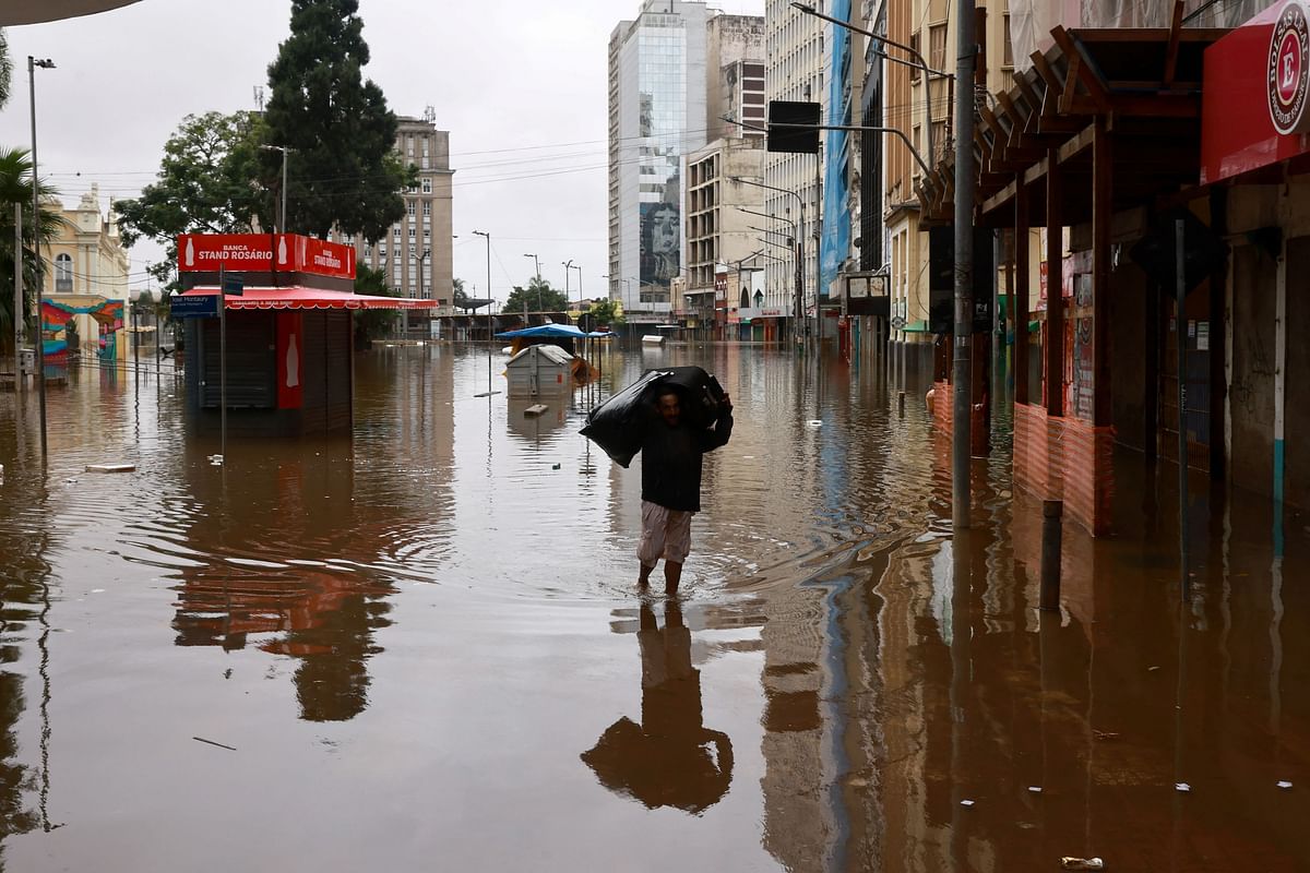 A man carries a bag at a flooded street in downtown Porto Alegre, Rio Grande do Sul, Brazil.