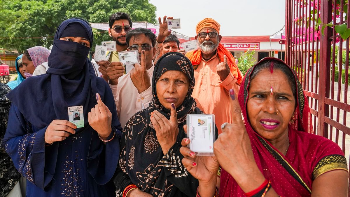 People show their ink-marked fingers after casting vote during the third phase of Lok Sabha elections, in Budaun, Uttar Pradesh.
