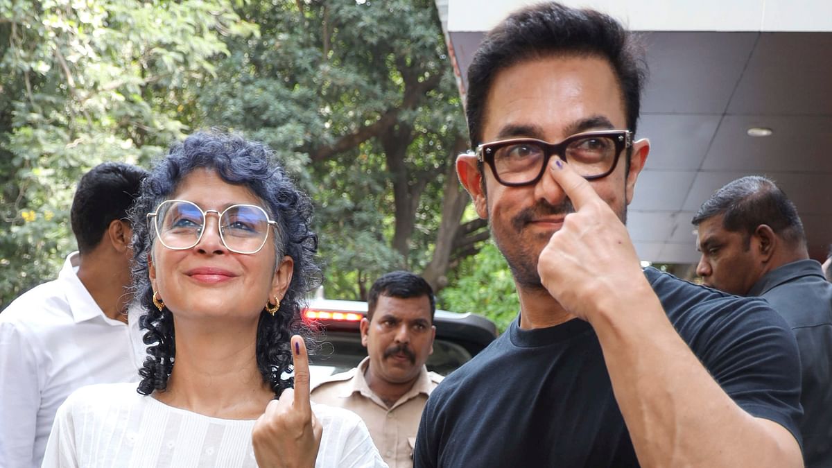 Actor Aamir Khan and filmmaker Kiran Rao show their fingers marked with indelible ink after casting their votes during the fifth phase of Lok Sabha elections, in Mumbai.