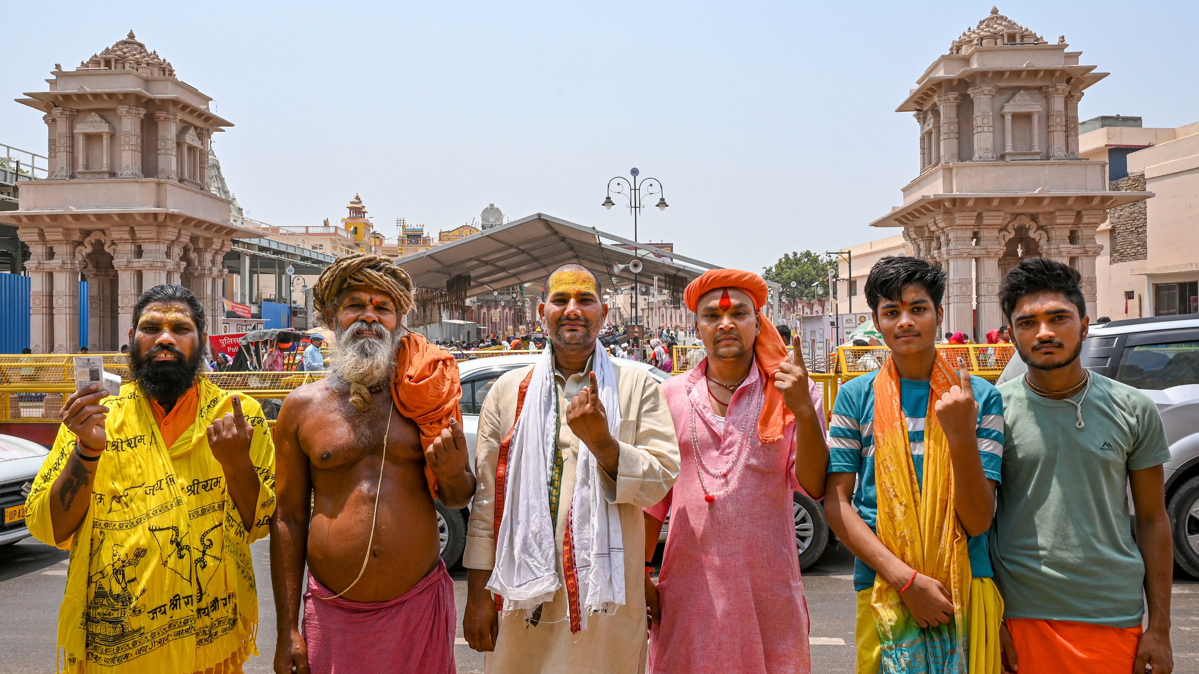 Sadhus show their inked fingers while taking pictures in front of the Ram temple after voting in the fifth phase of Lok Sabha polls in Ayodhya, Updown.