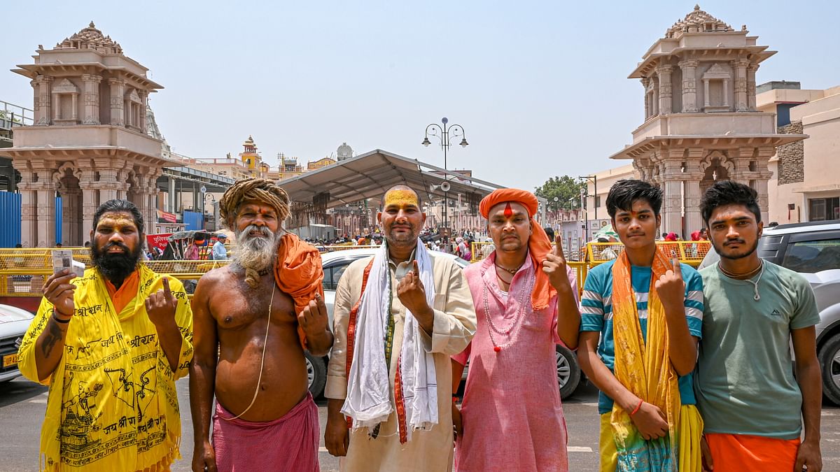 Sadhus show their inked fingers as they pose for photographs in front of the Ram temple after casting votes during the 5th phase of Lok Sabha polls, in Ayodhya, UP.