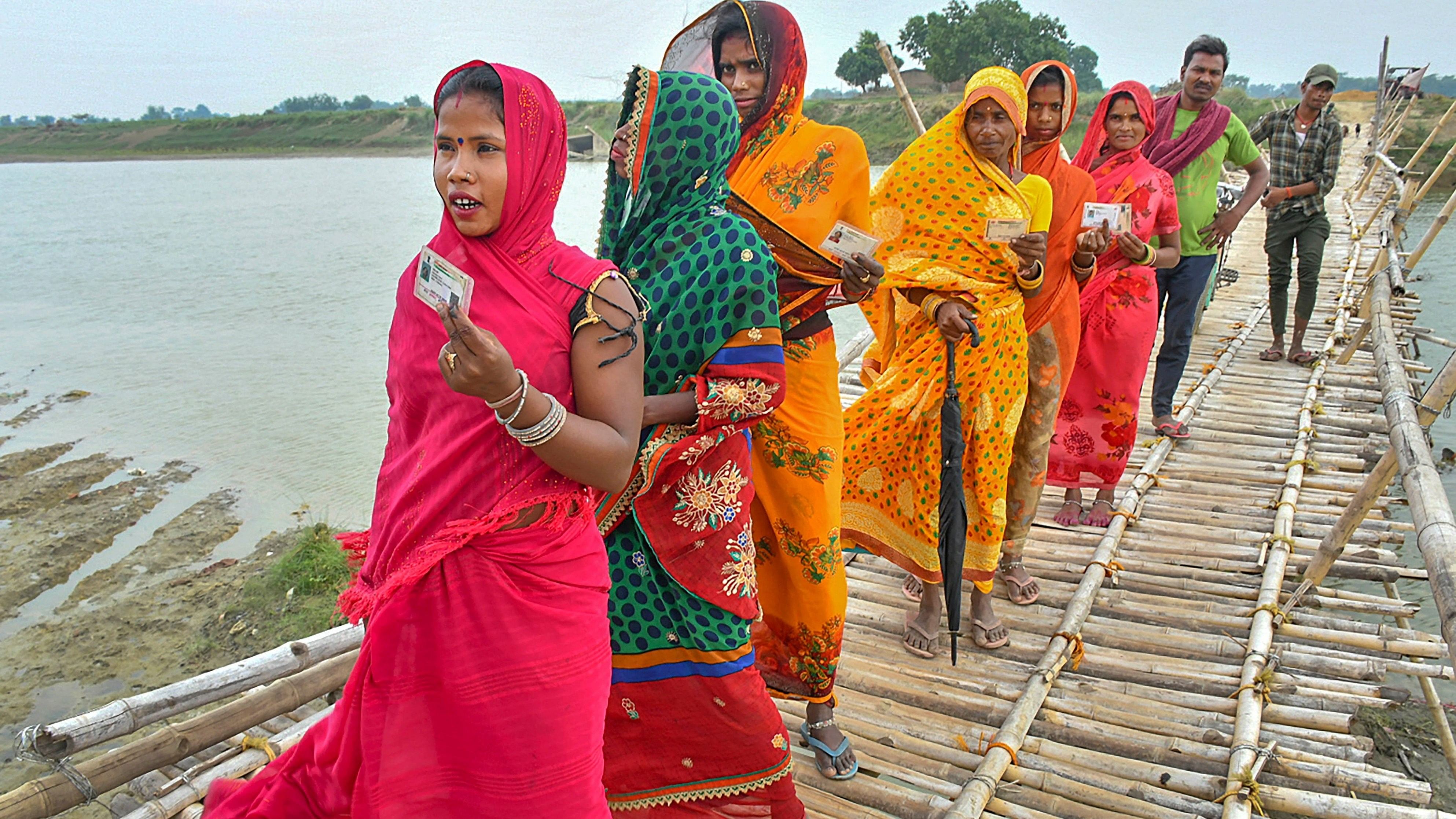 Voters cross a bridge on their way to a polling station to cast their vote in the fifth phase of Lok Sabha elections in Muzaffarpur, Bihar.