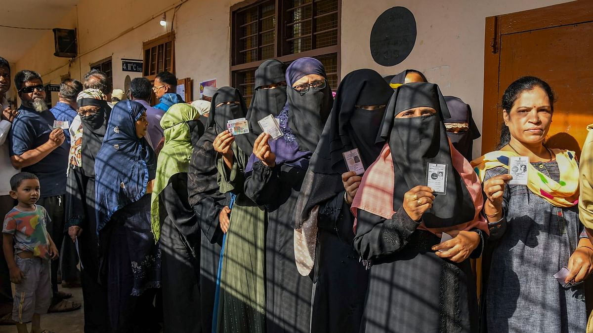 People wait in queues to cast their votes at a polling station during the third phase of Lok Sabha polls, in Karnataka.
