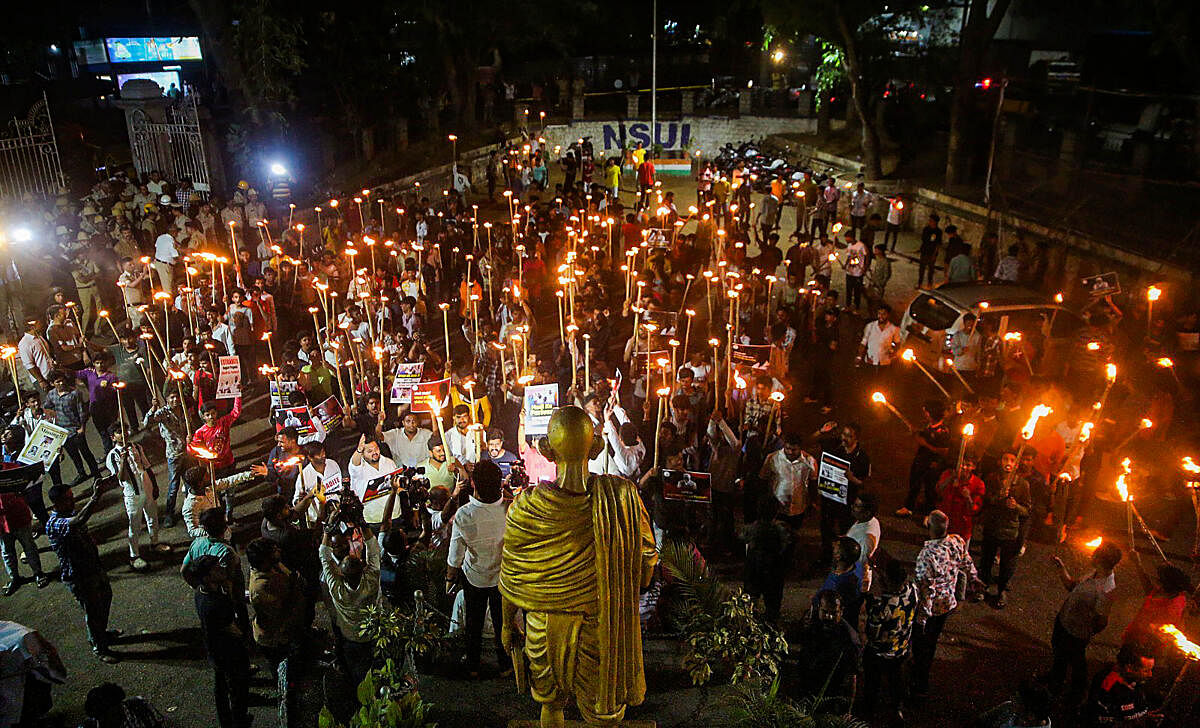 People take part in a torch light protest against Prajwal Revanna, in Bengaluru.