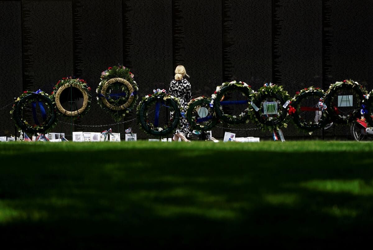 A woman walks by floral wreaths at the Vietnam Veterans Memorial after the Memorial Day holiday on the National Mall in Washington.