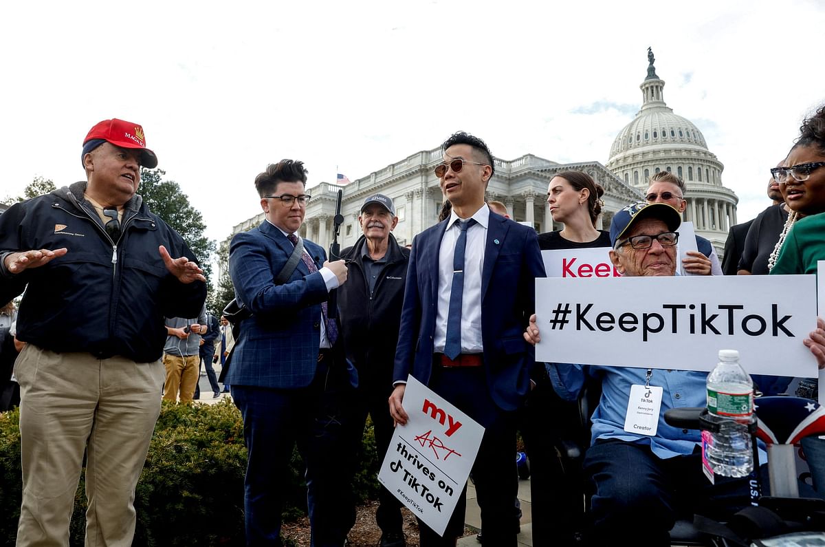 A man wearing a Maga hat who said TikTok should be banned, speaks to TikTok creators before they hold a news conference in support of TikTok, at the House Triangle at the United States Capitol in Washington.