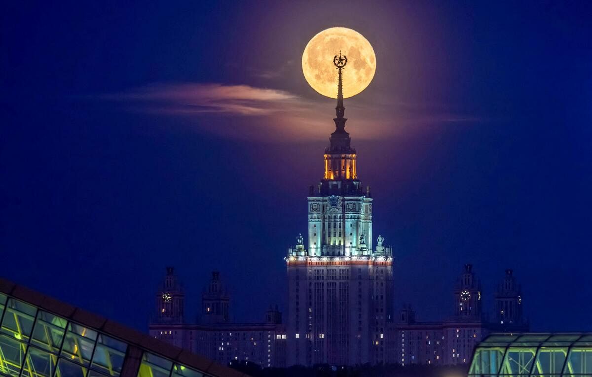 The full moon, also known as the Flower Moon, is seen behind Lomonosov Moscow State University in the city of Moscow, Russia, May 24, 2024.