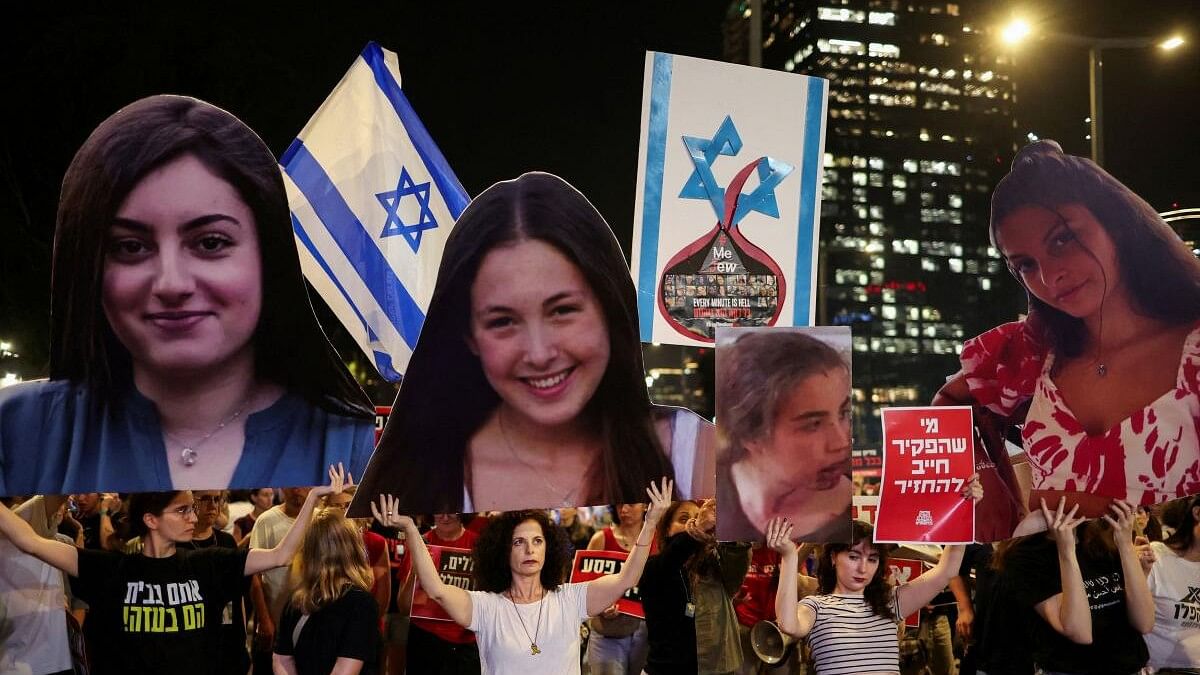 Demonstrators hold up cutouts of hostages during a protest demanding the immediate release of hostages, after the release of a video showing the capture of female Israeli soldiers before they were taken to Gaza during the deadly October 7 attack by the Palestinian Islamist group Hamas, near the Ministry of Defence in Tel Aviv, Israel May 22, 2024.