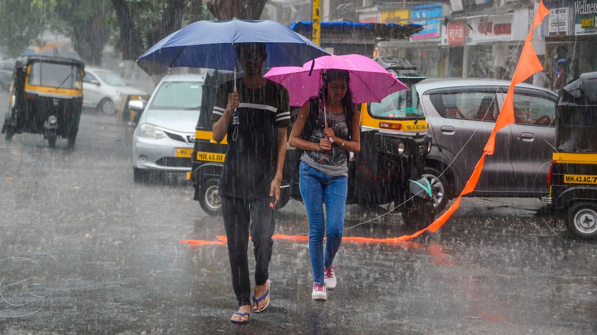 Commuters make their way through a street during heavy rains in Mumbai.