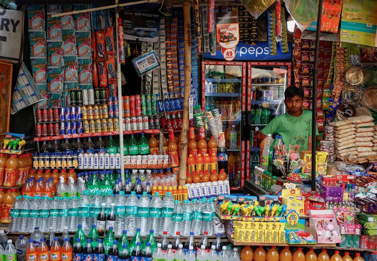 A vendor selling snacks and refreshment drinks waits for customers outside Alipore Zoological Garden on a hot summer day in Kolkata.