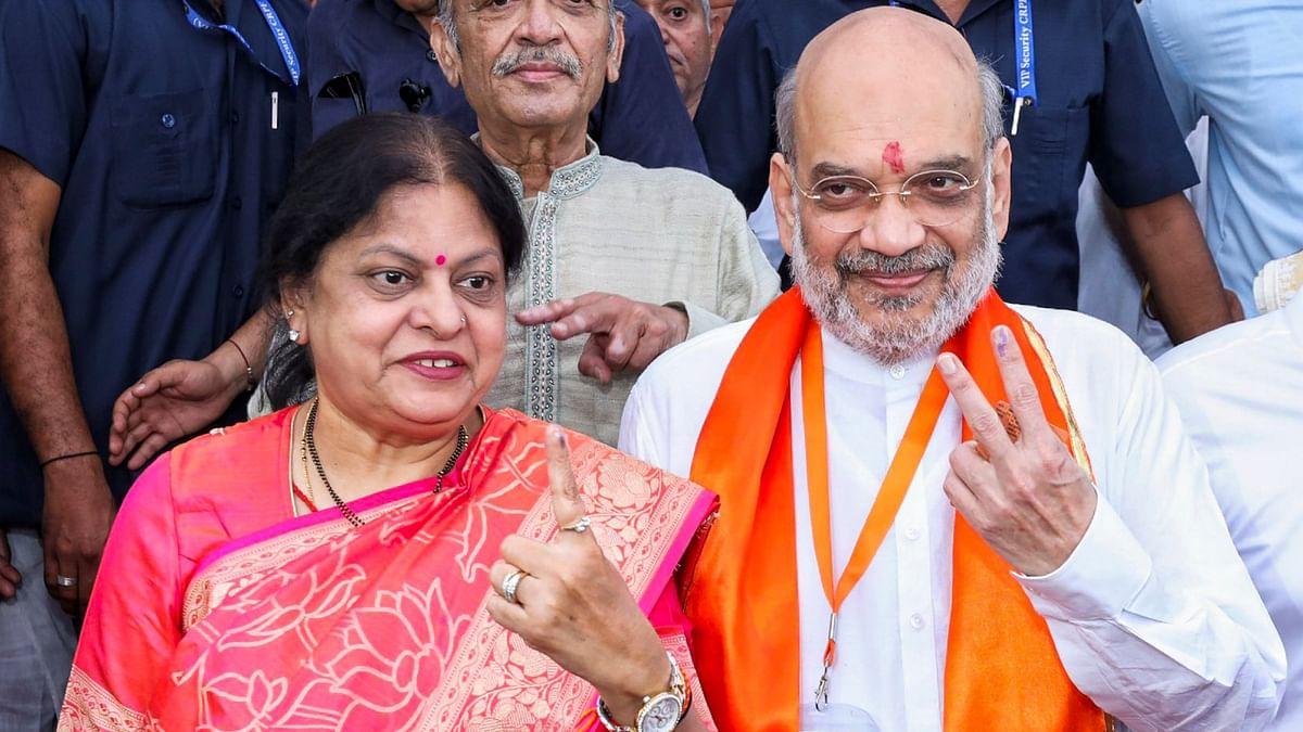 Union Home Minister Amit Shah and his wife Sonal Shah show ink-marked fingers after casting their vote in Ahmedabad.
