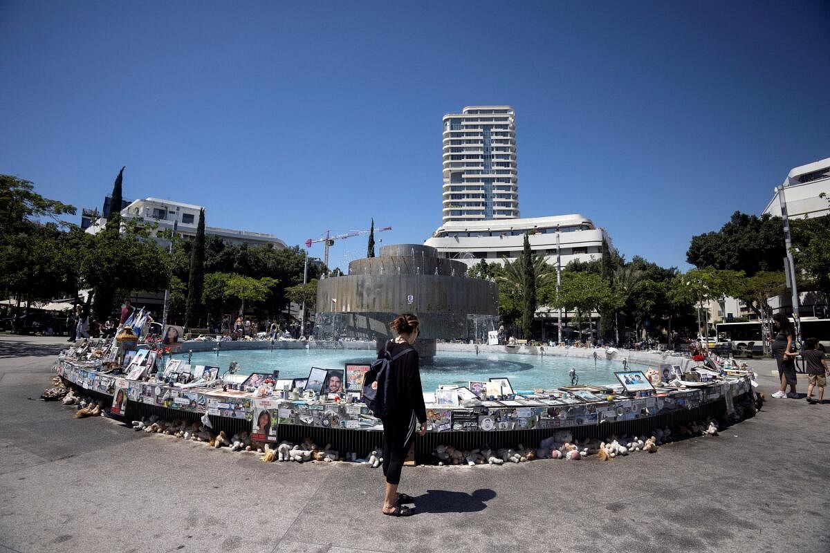 A woman looks at memorabilia and pictures of the hostages kidnapped in the deadly October 7 attack on Israel by the Palestinian Islamist group Hamas, at Dizengoff Square in Tel Aviv, Israel, May 16, 2024.