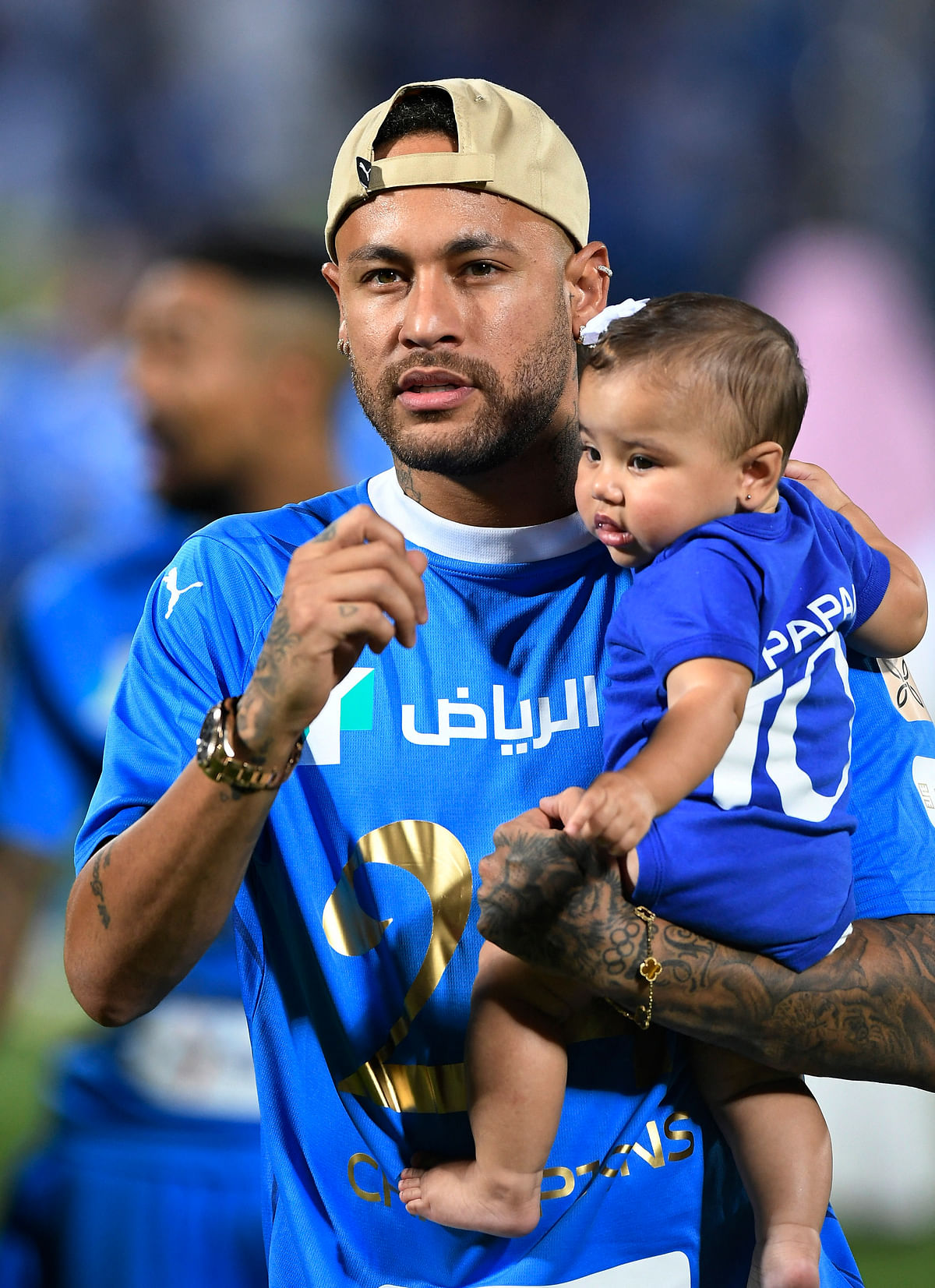 Neymar walks on the pitch holding his daughter Mavie after Al Hilal win the Saudi Pro League.