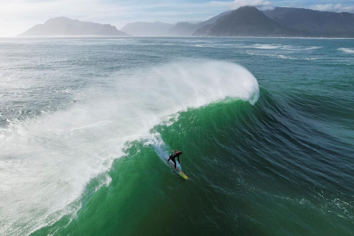 A drone view shows a surfer riding a wave at Sunset offshore reef as seasonal cold fronts drive big swells into the Cape Peninsula in Cape Town, South Africa May 17, 2024