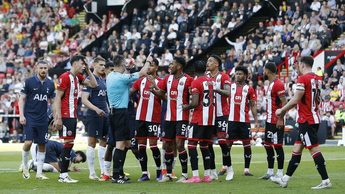 Sheffield United's Andre Brooks is shown a red card by referee Andrew Madley before being rescinded following a VAR review.