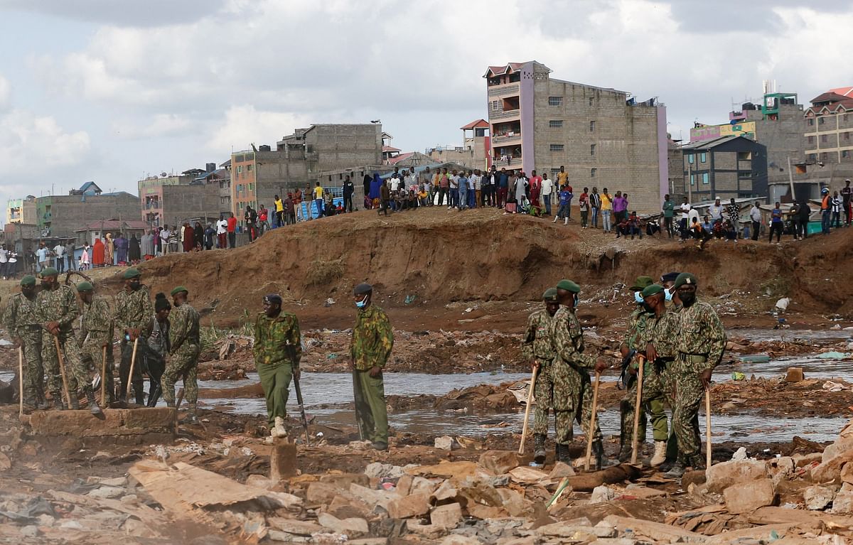 Kenyan security officers stand guard during the search and rescue operations on the rubble of a residential flat built on riparian land, that collapsed while undergoing demolition in Nairobi