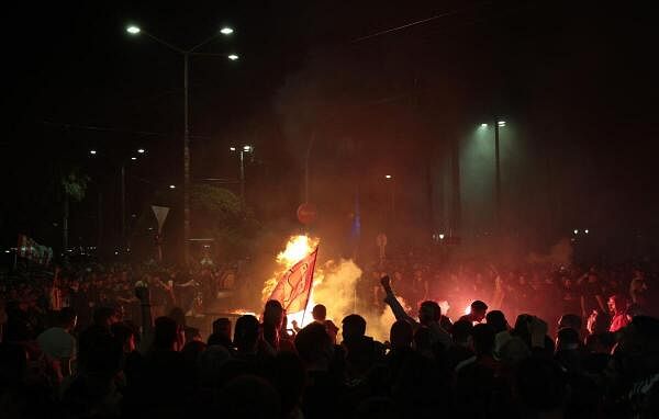 Olympiacos fans celebrate with flares in Piraeus after reaching the Europa Conference League final.