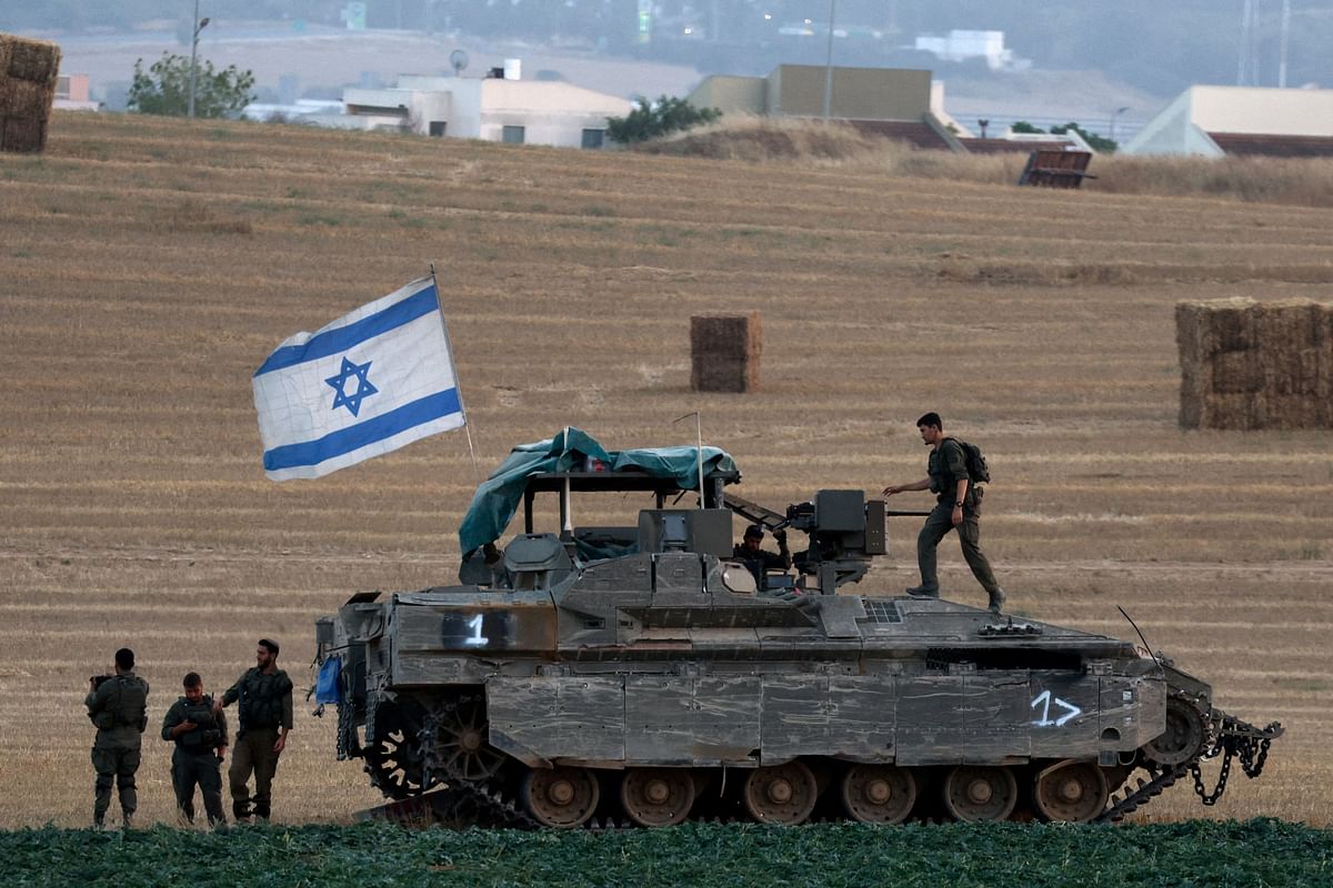 Israeli soldiers with an armoured personnel carrier (APC) operate near the Israel-Gaza border.