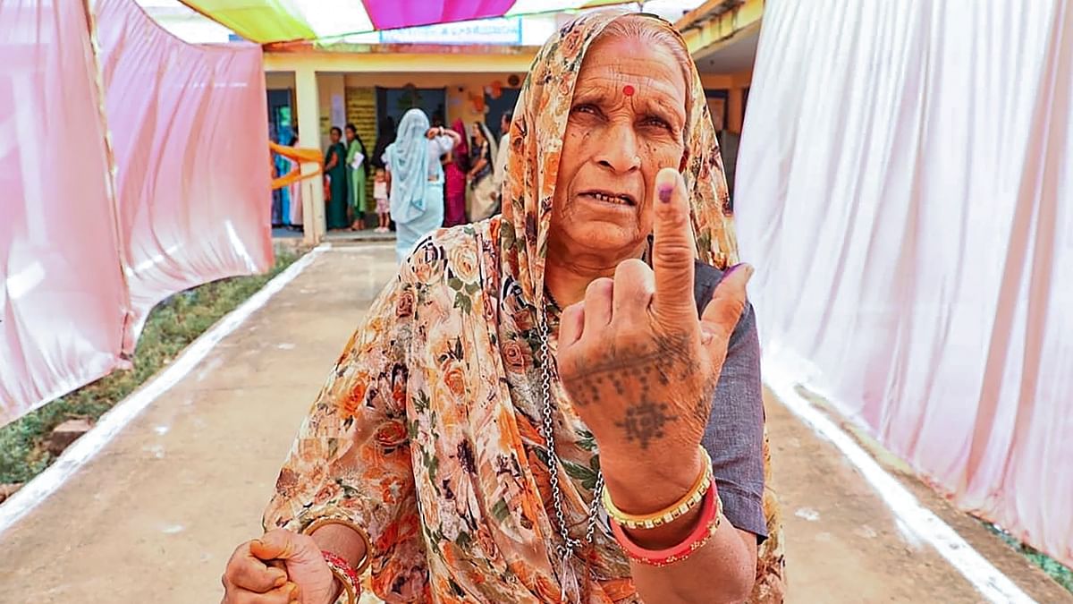 An elderly woman shows her inked finger after casting her vote at a polling booth during the fourth phase of General Elections 2024 at Ashta in Sehore.