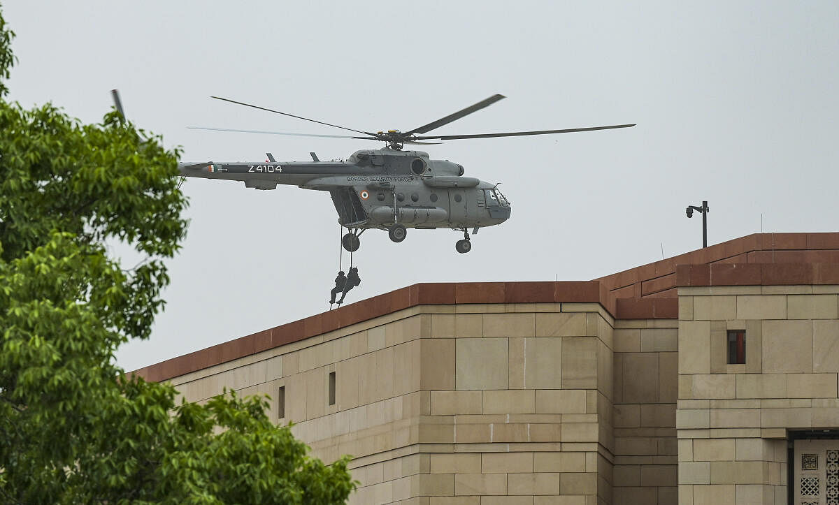 A helicopter hovers during a mock drill, at the Parliament building, in New Delhi.