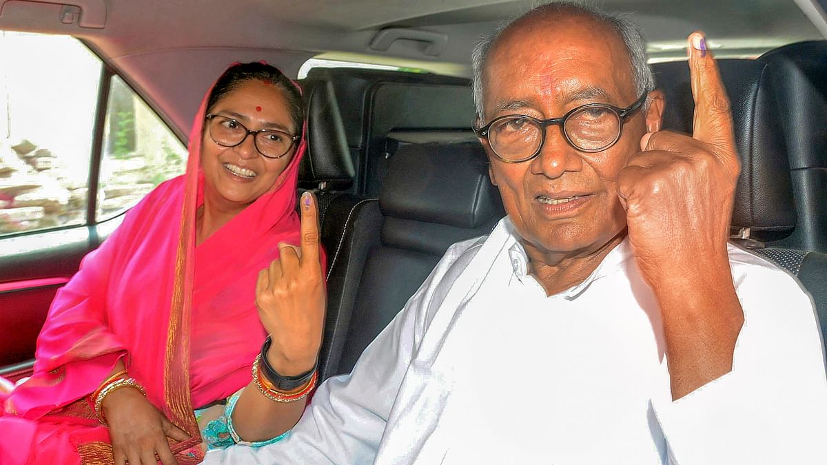 Senior Congress leader Digvijaya Singh and his wife Amrita Singh show their fingers marked with indelible ink after casting their vote for the third phase of Lok Sabha elections, in Bhopal.
