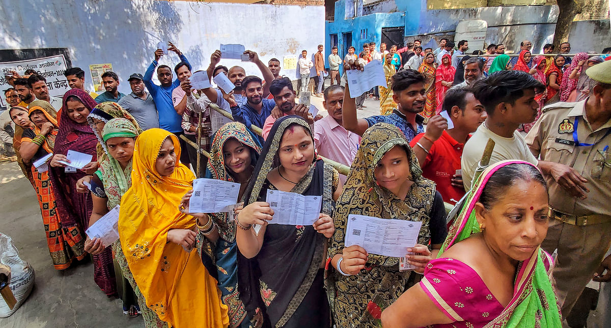 People wait to cast their vote for the third phase of Lok Sabha elections, in Agra.
