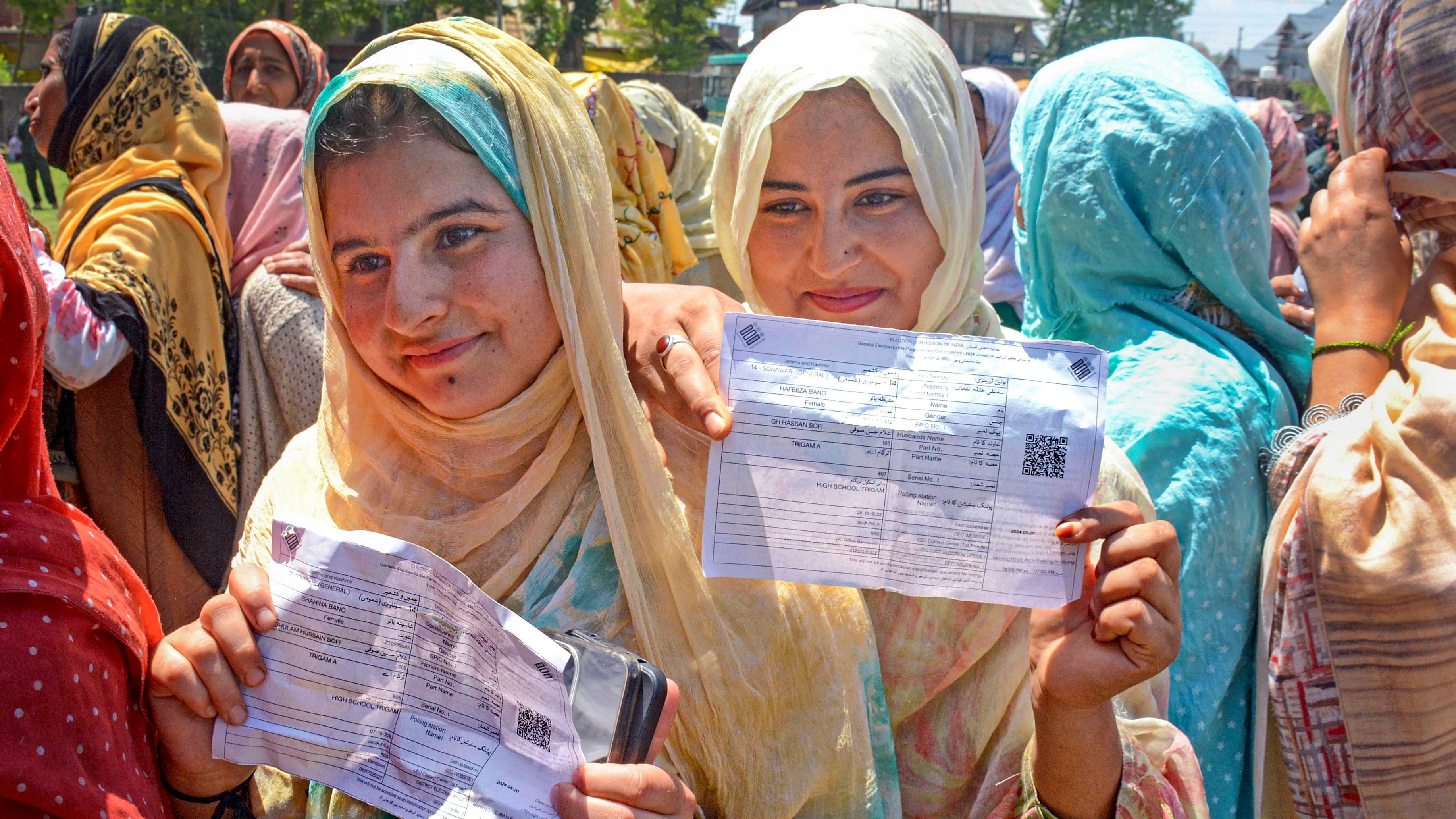 First-time voters show their ballot papers as they wait to vote at a polling station for the fifth phase of Lok Sabha elections in Bandipore, J&K.