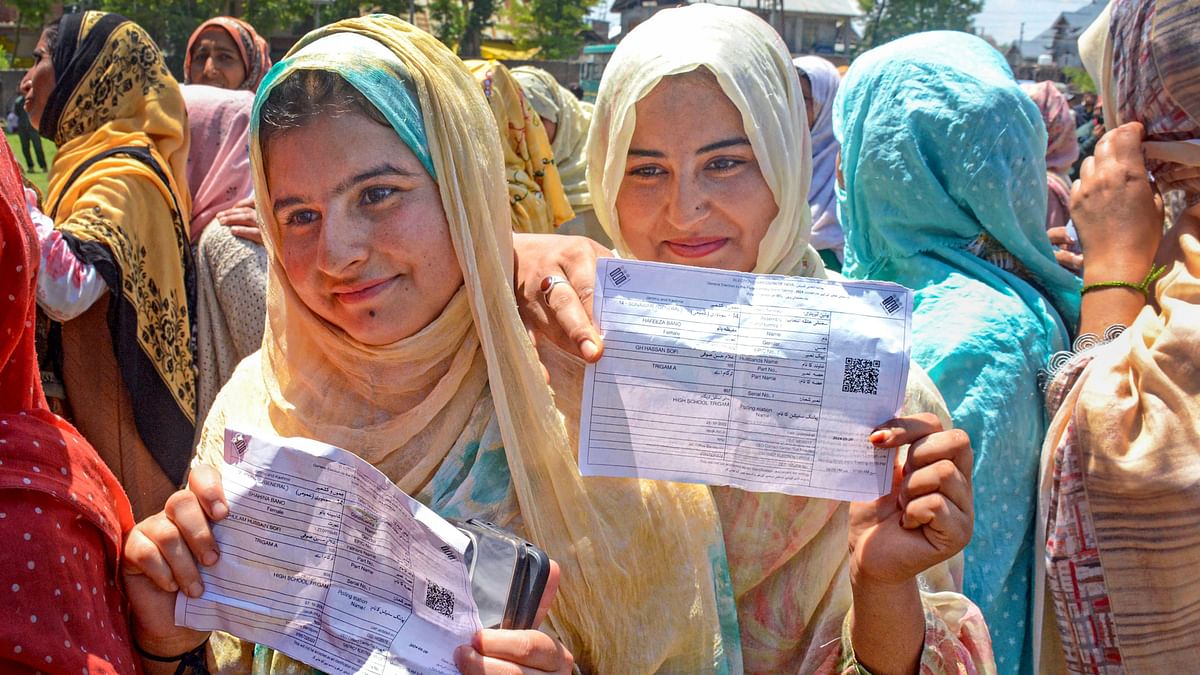 First time voters show their voter slips as they wait at a polling station to cast their votes for the fifth phase of Lok Sabha elections, in Bandipore, J&amp;K.