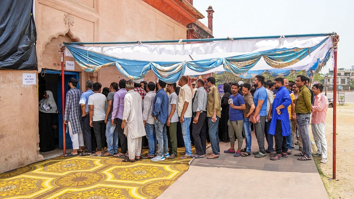 Voters wait in a queue at a polling station to cast their votes on a hot summer day for the fifth phase of Lok Sabha elections, in Lucknow.