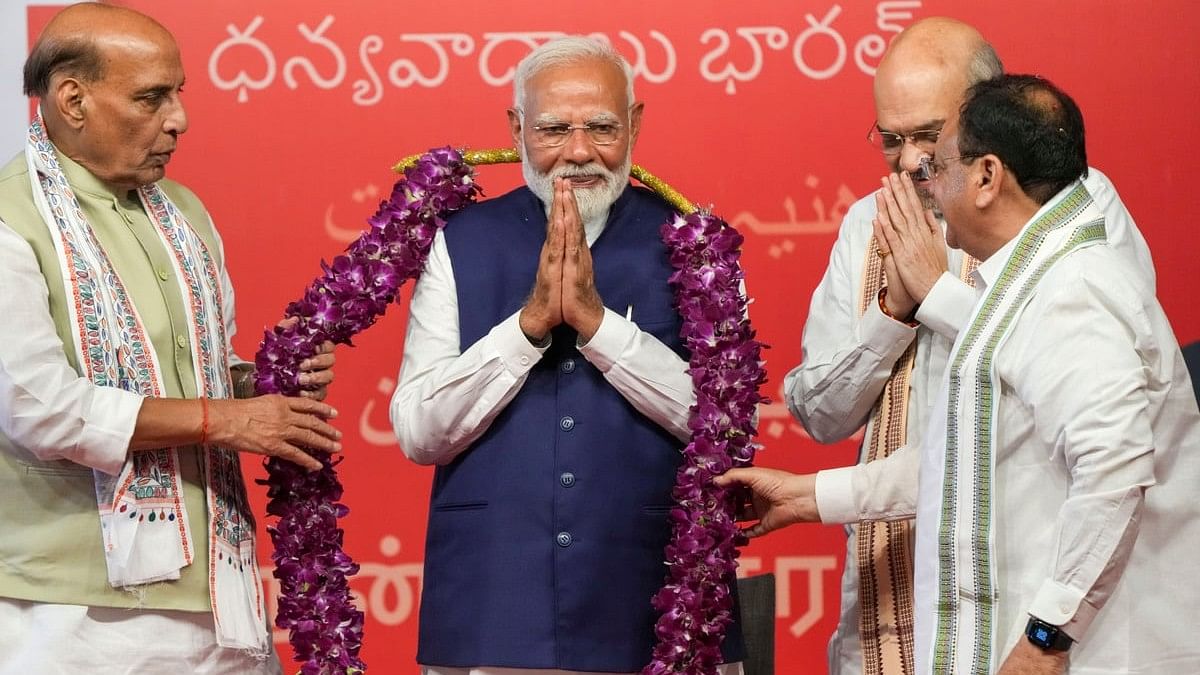 Prime Minister Narendra Modi being garlanded by Union Home Minister Amit Shah, Union Defence Minister Rajnath Singh and BJP National President JP Nadda during a meeting at the party headquarters as the party leads in the Lok Sabha elections amid the counting of votes, in New Delhi.