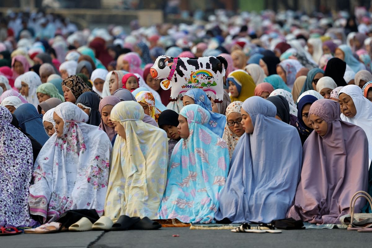 Muslim attend morning mass prayers on the street during Eid al-Adha celebrations in Jakarta