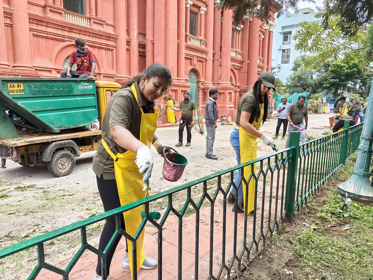 Volunteers paint the fence around the Government Museum on Kasturba Road. PIC: Arun Pai