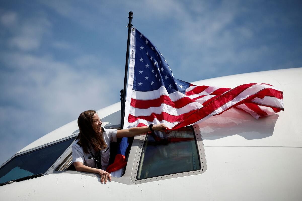 A woman stands in a cockpit window with the U.S. flag at the Deauville-Normandie Airport in Deauville, Normandy region, France, June 3, 2024. 