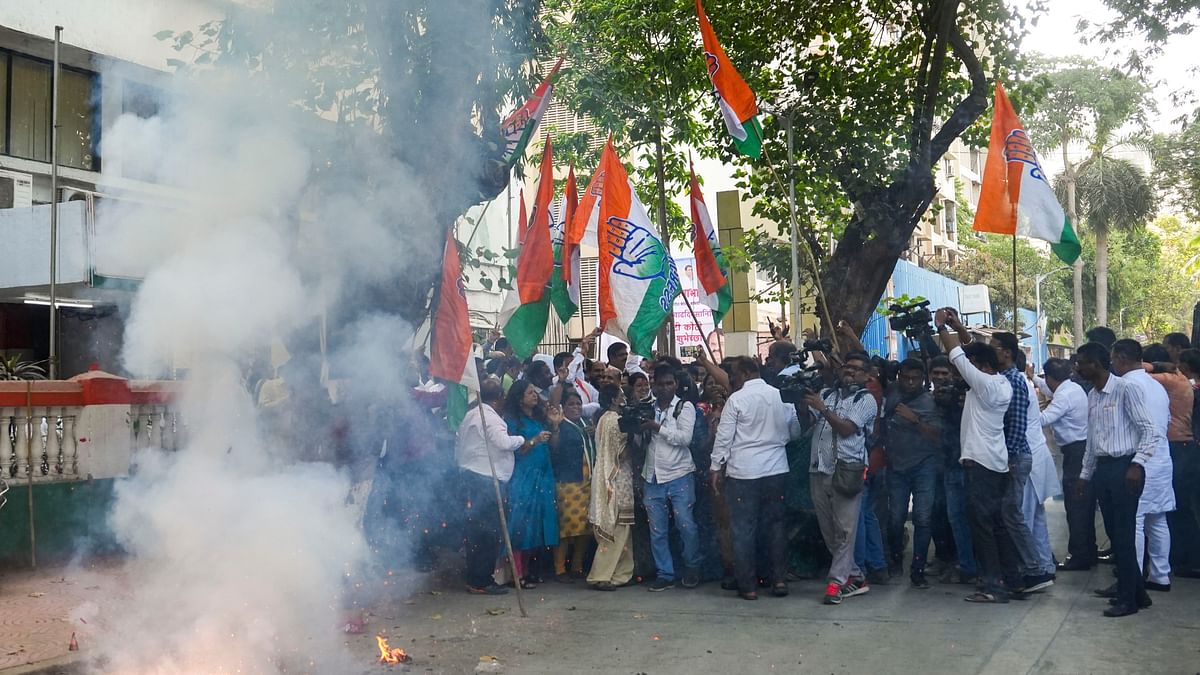 Congress supporters celebrate the party's lead during counting of votes for Lok Sabha elections, in Mumbai.