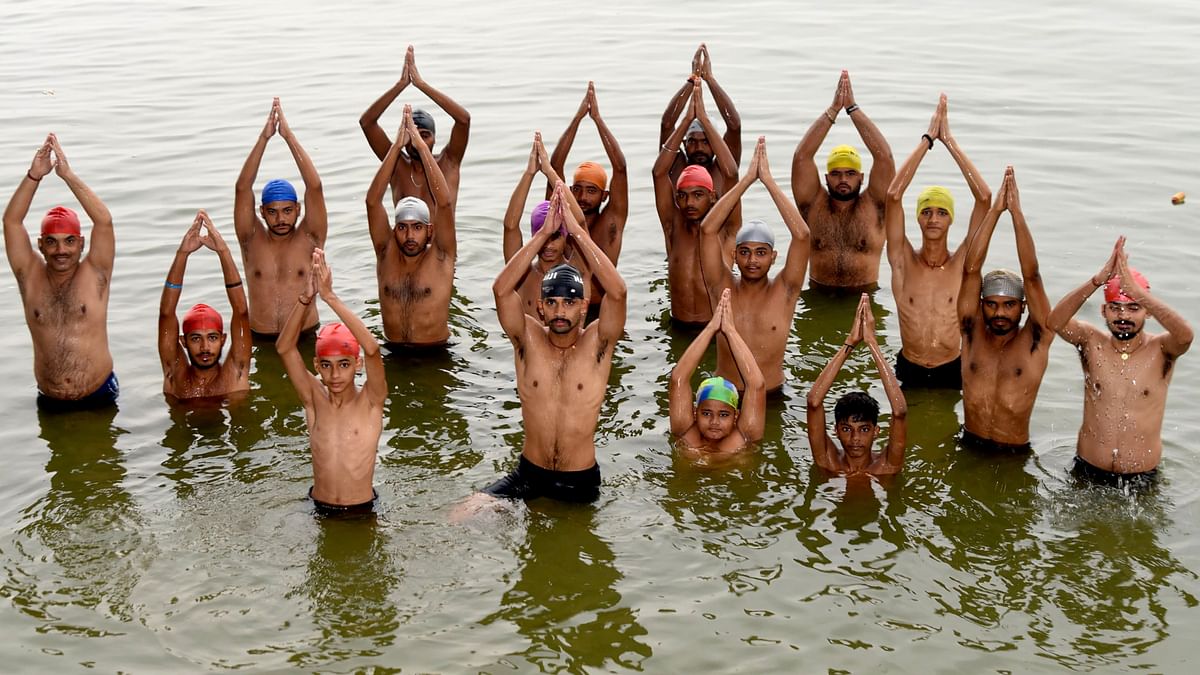People perform yoga in the Ganga river on the occasion of the 10th International Day of Yoga, in Patna.