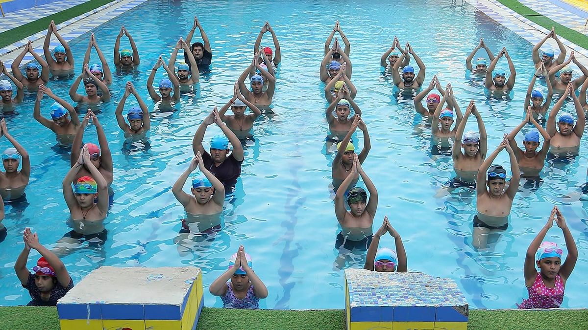 Swimmers perform yoga inside a pool on the 10th International Day of Yoga, in Mathura.