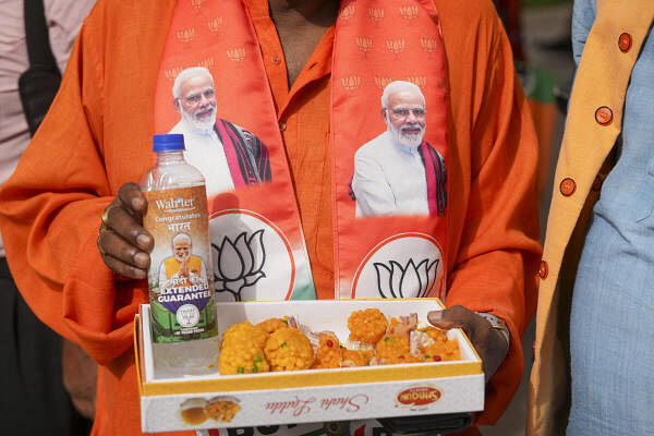A BJP worker holds 'laddoos' on the day of counting of votes for Lok Sabha elections, in New Delhi, Tuesday, June 4, 2024. 