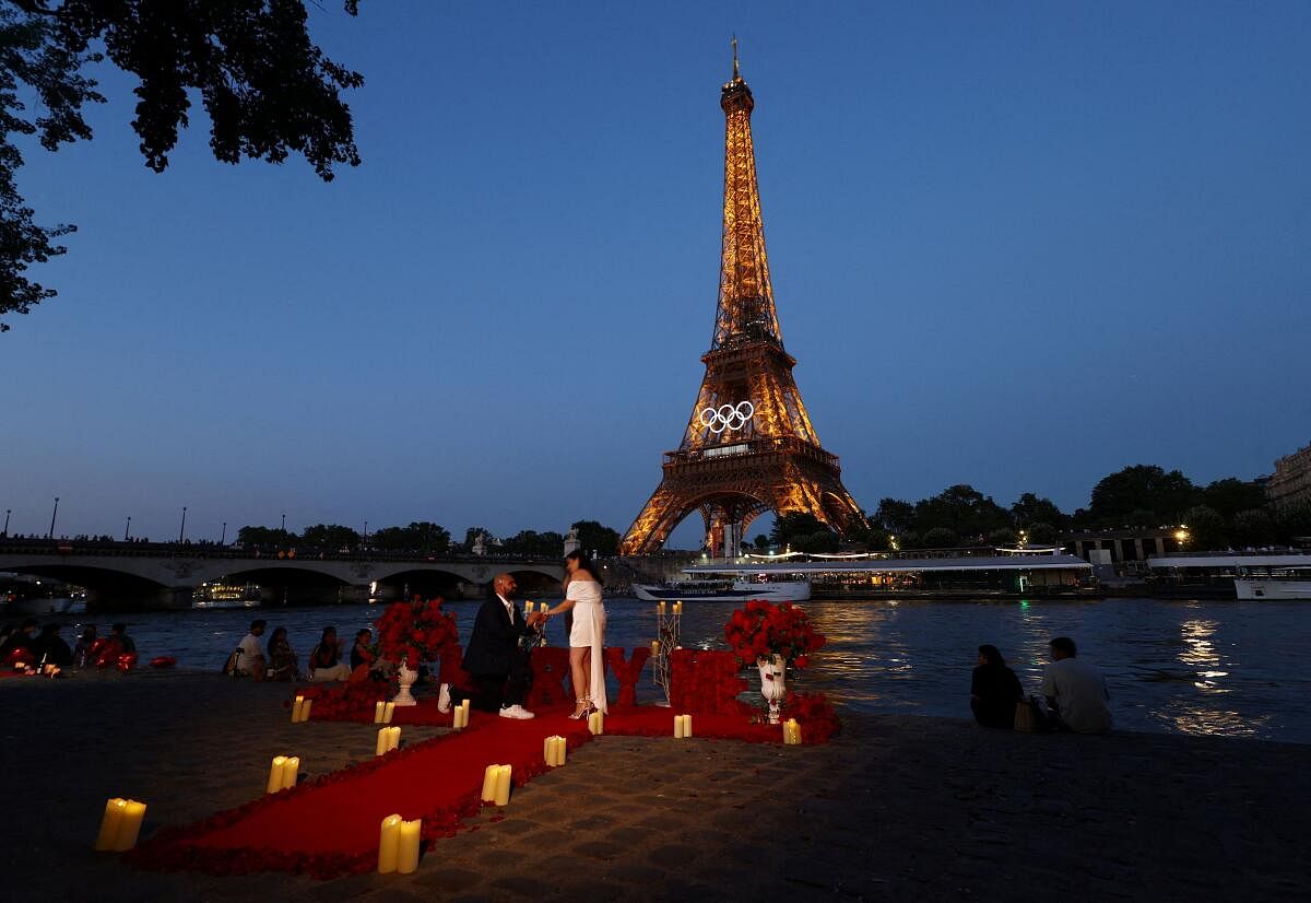 Gabriel from Los Angeles proposes to Cindy by the Eiffel Tower which displays the Olympic rings ahead of the Paris 2024 Olympic games in Paris.