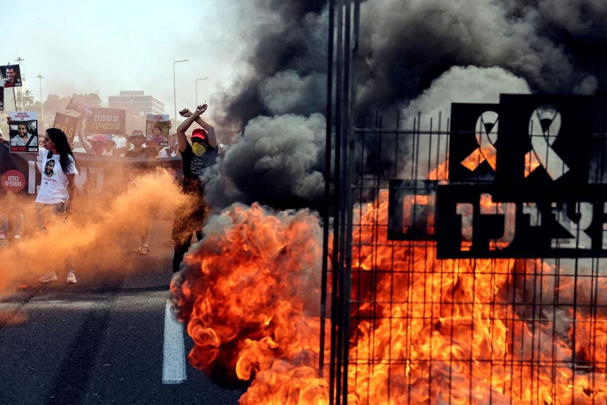 A fire blazes as protesters block a road during a demonstration demanding the immediate return of hostages who were kidnapped during the deadly October 7 attack on Israel by Hamas, in Tel Aviv, Israel June 27, 2024.