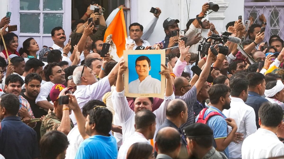 Congress workers celebrate before the party's press conference amid the counting of votes for the Lok Sabha elections, at the party headquarters, in New Delhi.